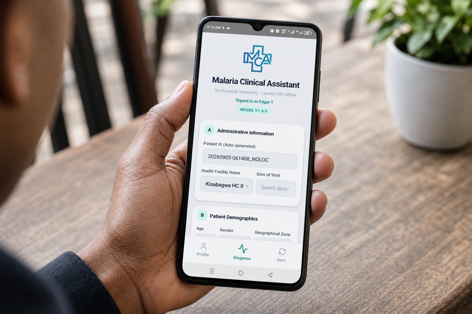 Hand holding a phone with the Malaria Clinical Assistant screening app